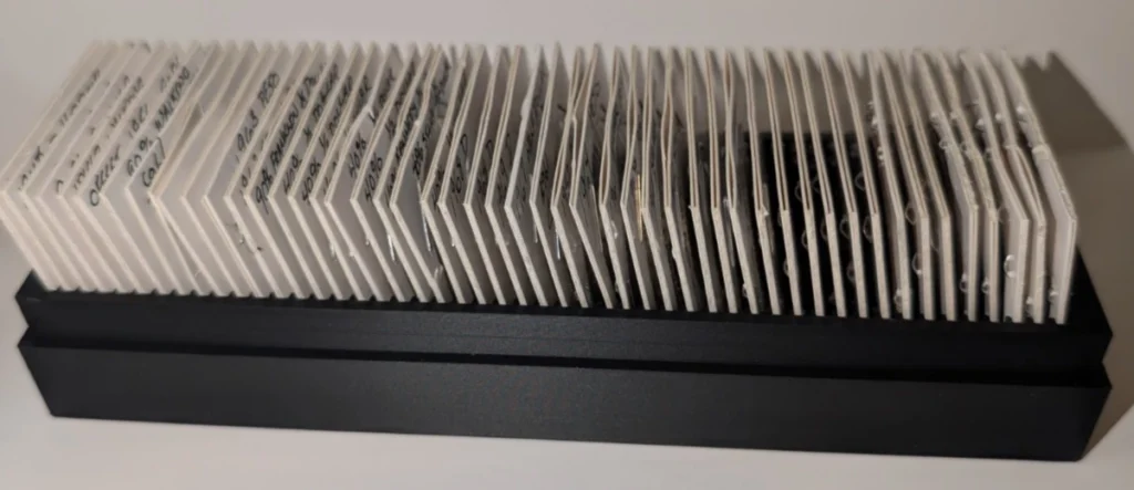 Black 50-slot 2x2 coin flip storage holder filled with individual coin flips