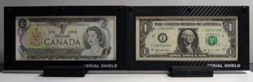 Close front view of two black carbon-fiber 4-mil currency display frames with sample U.S. banknotes