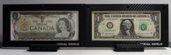 Close front view of two black carbon-fiber 4-mil currency display frames with sample U.S. banknotes