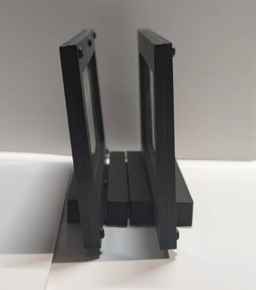 Side profile of two currency frames showing the upright display stands
