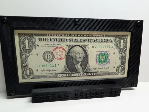 Angled front view of a premium currency frame and its black display stand