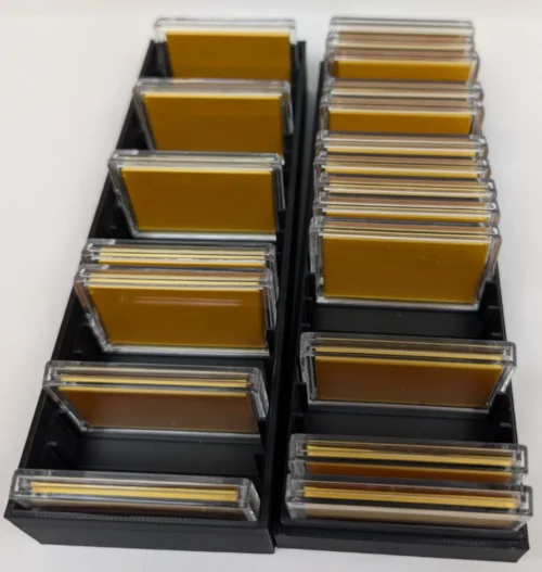Four open black 20-slot bar capsule storage boxes filled with 1 oz bar capsules
